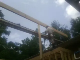 Carpenter setting a ridge beam over a new addition frame — Ice Dam Removal by Roofing Brothers in Crystal Spring