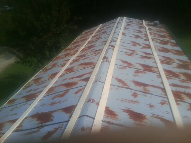 Rusted metal roof panels with new wood purlins before replacement — Storm Damage Roof Repair in Crystal Spring by Roofing Brothers