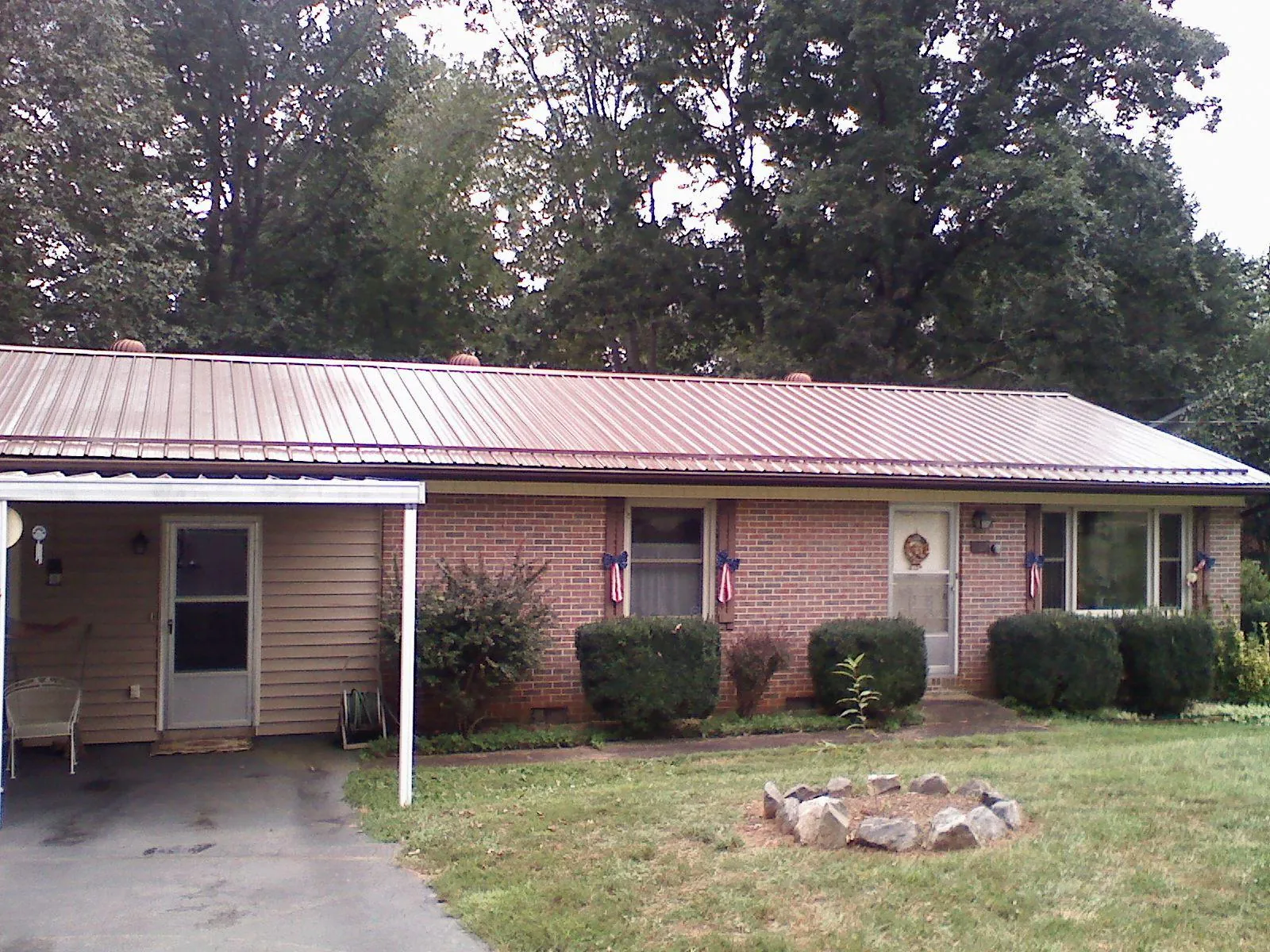 Bronze metal roof and carport on a brick ranch home — Roof Repair work by our crew in Crystal Spring